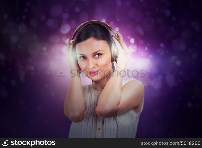 Beautiful woman listening music on a background of lights