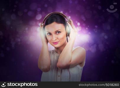 Beautiful woman listening music on a background of lights