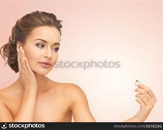 beautiful woman looking at wedding ring and thinking. woman with wedding ring