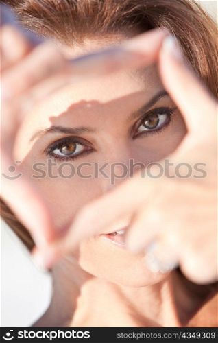 Beautiful Woman Looking Through Her Hands Making A Frame