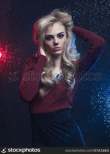 Beautiful woman looking through the window with rain drops