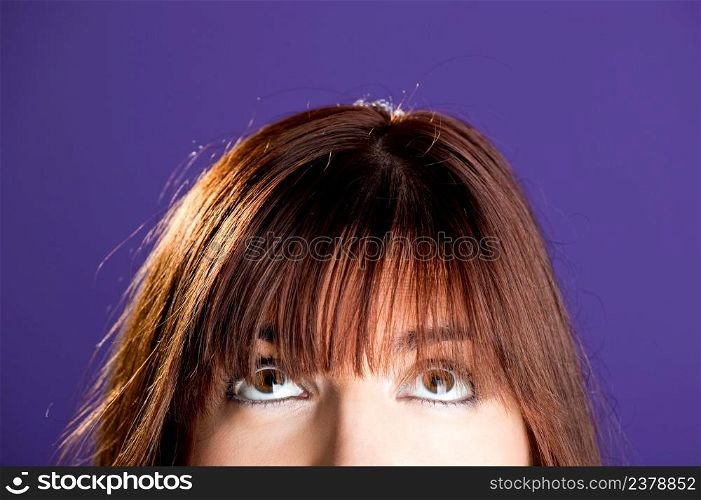 Beautiful woman looking to the top over a violet background