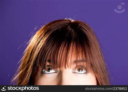 Beautiful woman looking to the top over a violet background