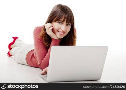 Beautiful woman lying on the floor and looking to the camera while working on a laptop