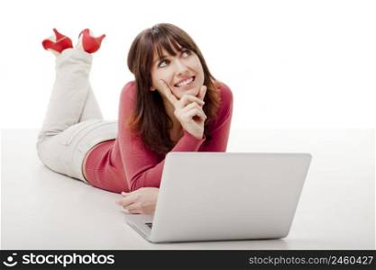 Beautiful woman lying on the floor and thinking while working on a laptop