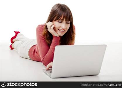 Beautiful woman lying on the floor and working on a laptop