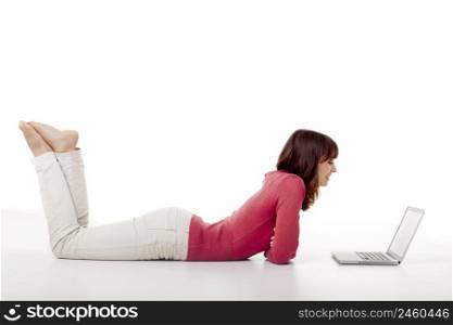Beautiful woman lying on the floor and working with a laptop