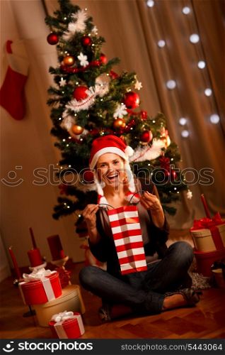 Beautiful woman near Christmas tree opening gifts&#xA;