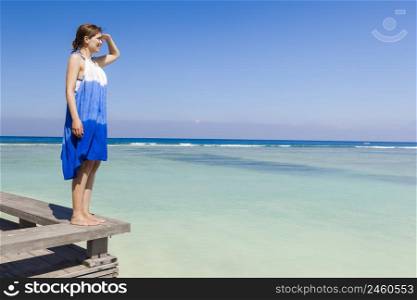 Beautiful woman on a beautiful tropical beach looking somewhere
