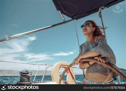 Beautiful Woman on a Helm of a Boat. Having Fun. Enjoying Amazing Sunny Summer Day. Water Sport. Peaceful Vacation.. Happy Girl Sailing
