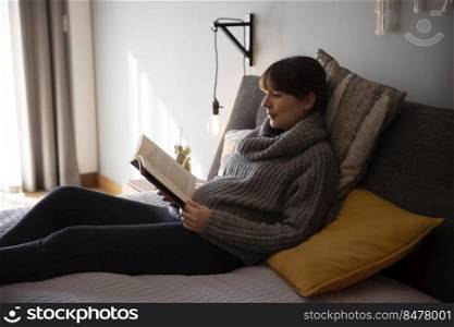 Beautiful woman on bed and reading a book