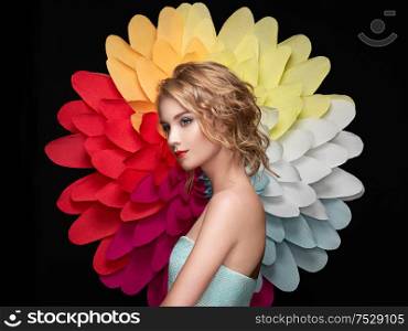 Beautiful woman on the background of a large flower. Beauty summer model girl with rainbow chrysanthemum. Young woman with elegant hairstyle and makeup. Fashion photo