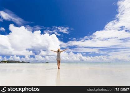 Beautiful woman on the beach enjoying the beauty of Praslin, Seychelles