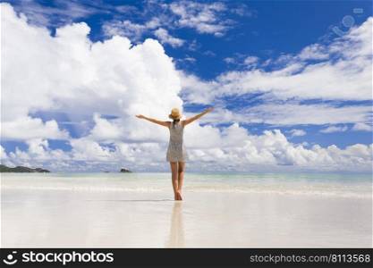 Beautiful woman on the beach enjoying the beauty of Praslin, Seychelles