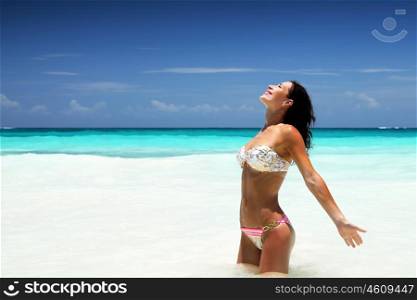 Beautiful woman on the beach, standing in sea, enjoying bright sun light, happy summer holidays, travels to Caribbean Sea, Cancun, Mexico, North America, enjoying life&#xA;