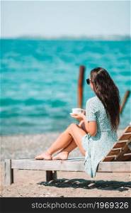 Beautiful woman on the beach vacation. Young woman with cup of hot coffee enjoy holidays