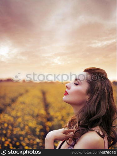 Beautiful woman on the summer flower meadow