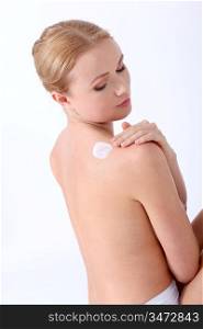 beautiful woman on white background applying moisturizer