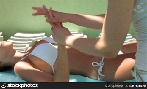 Beautiful woman outdoor receiving a massage at spa resort.