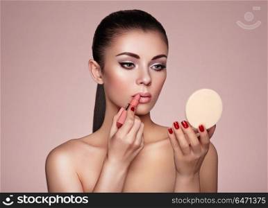 Beautiful woman paints lips with lipstick. Beautiful Woman Paints Lips with Lipstick. Beautiful Woman Face. Makeup Detail. Beauty Lady with Perfect Skin. Lips and Nails Manicure. Make-up Artist