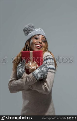 Beautiful woman portrait hold christmas gift. Smiling happy girl on gray background.