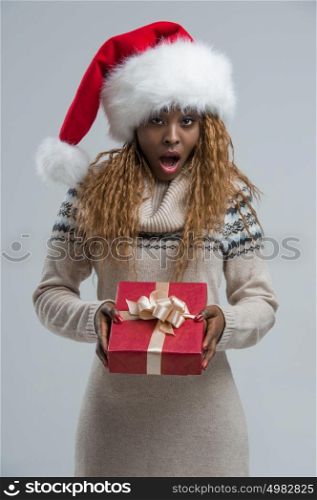 Beautiful woman portrait hold christmas gift. Smiling happy girl on gray background.