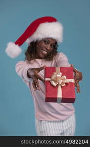 Beautiful woman portrait holding and sharing Christmas gift. Smiling happy african girl on blue background.