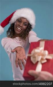 Beautiful woman portrait taking Christmas gift. Smiling happy african girl on blue background.