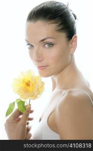 Beautiful woman portrait with yellow rose over white light background