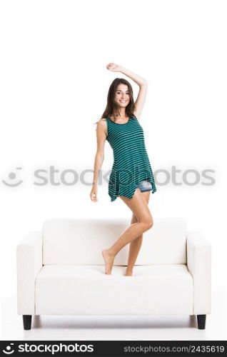 Beautiful woman posing in the sofa, isolated over a white background