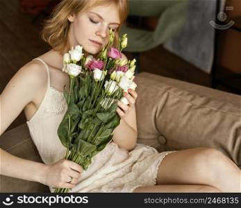 beautiful woman posing sofa while holding bouquet delicate spring flowers