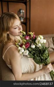 beautiful woman posing sofa while holding bouquet spring flowers