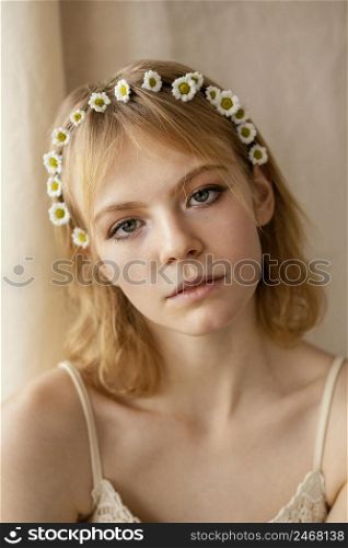 beautiful woman posing while wearing delicate spring flowers crown