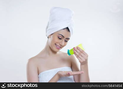 Beautiful woman pouring beauty product on palm over white background