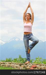 beautiful woman practise yoga. mountains in background.