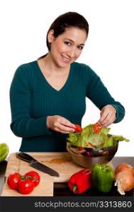 Beautiful woman preparing a delicious organic salad with lettuce, tomato, bell peppers and onion in kitchen, isolated.
