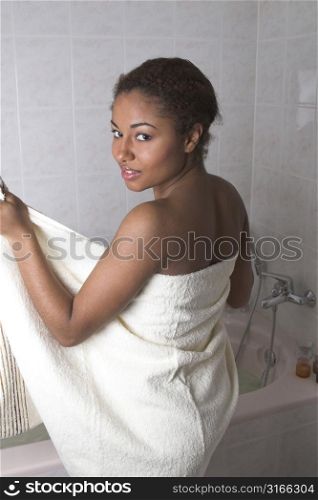 Beautiful woman preparing to step into the bathtub