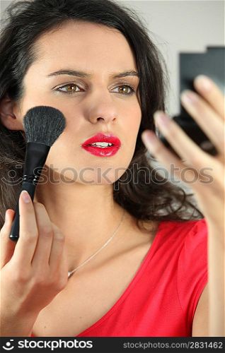 beautiful woman putting on some make up