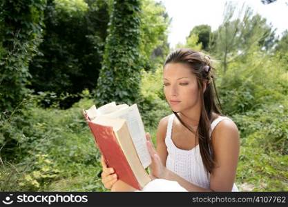 Beautiful woman reading happy a book in forest, green nature outdoor