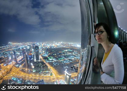 beautiful woman relax on balcony with amazing night city view in background