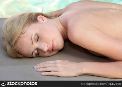 Beautiful woman relaxing on massage bed
