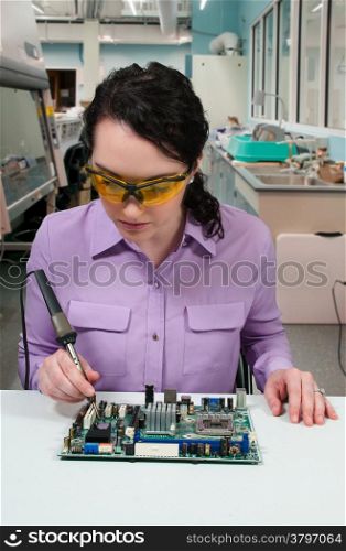 Beautiful woman repair soldering a printed circuit board