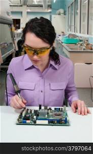 Beautiful woman repair soldering a printed circuit board