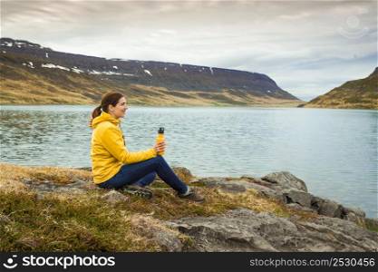Beautiful woman resting close to a beautiful lake