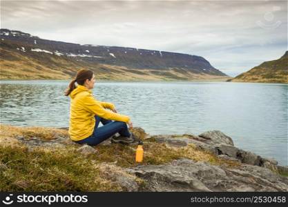 Beautiful woman resting close to a beautiful lake
