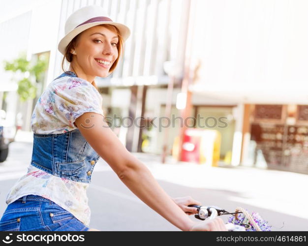 Beautiful woman riding on bike. Beautiful young woman riding on bike in city