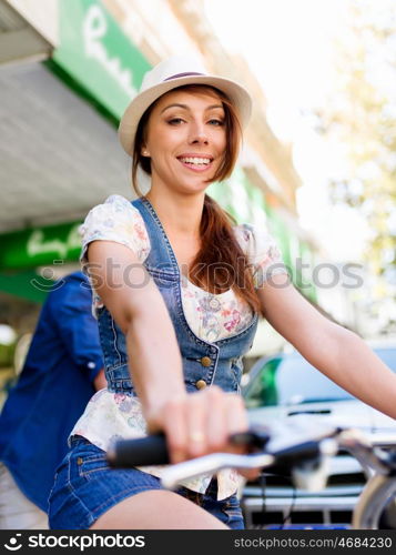 Beautiful woman riding on bike. Beautiful young woman riding on bike in city