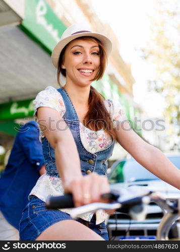 Beautiful woman riding on bike. Beautiful young woman riding on bike in city