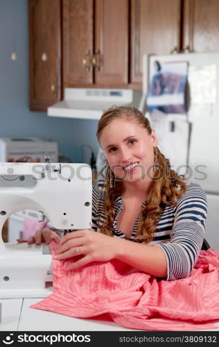 Beautiful woman seamstress with a sewing machine