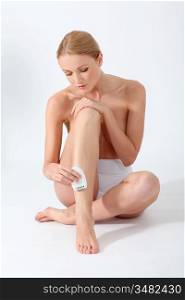 Beautiful woman shaving her legs
